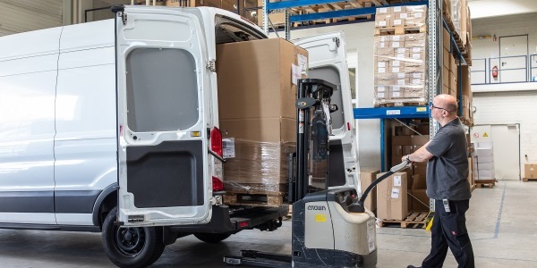 Lagerabeiter verlädt Ware in einen Transporter