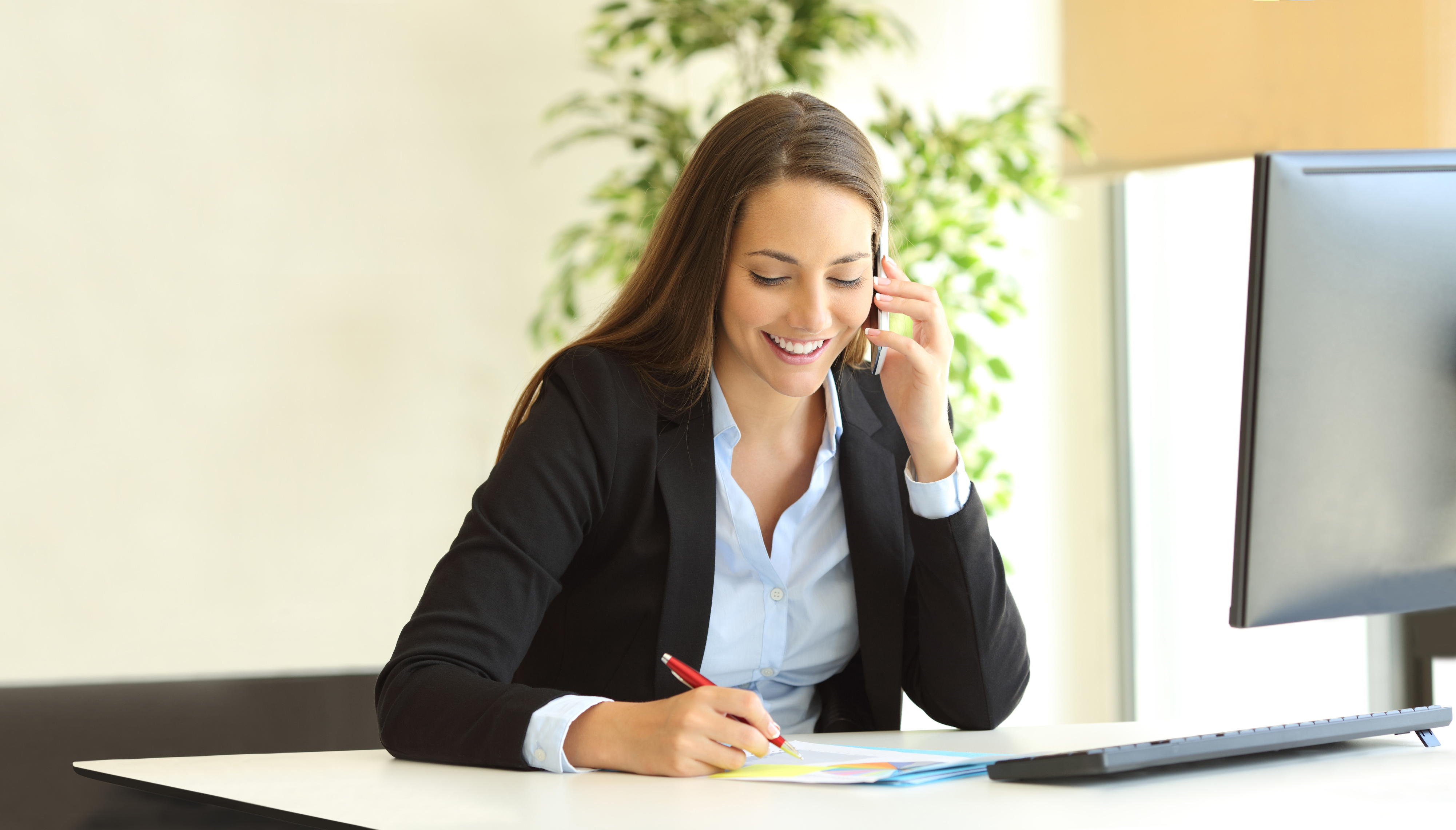 Frau telefoniert am Schreibtisch