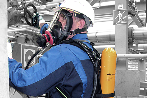 Arbeiter verwendet Druckluftschlauchgerät beim Einsatz in einem Gebäude